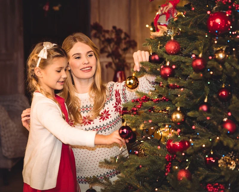 Mama si fiica alături de pomul de Crăciun